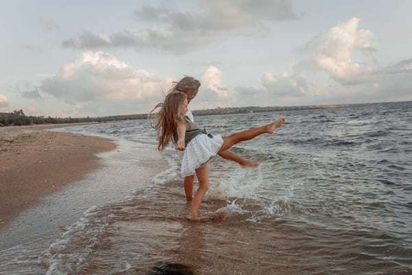 two people flicking water into the ocean with their feet