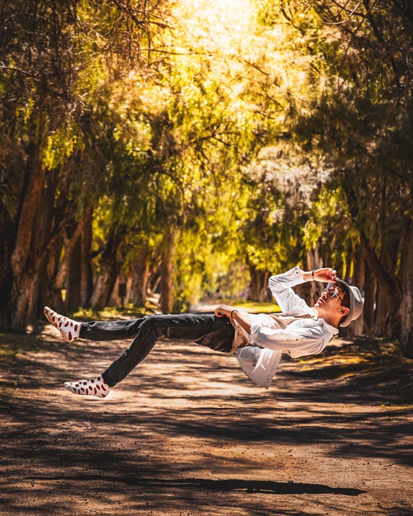 Man outside levitating in between trees