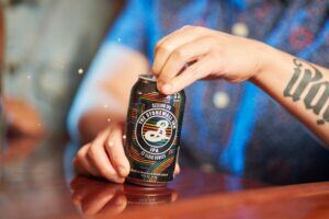 Person opening beer photo